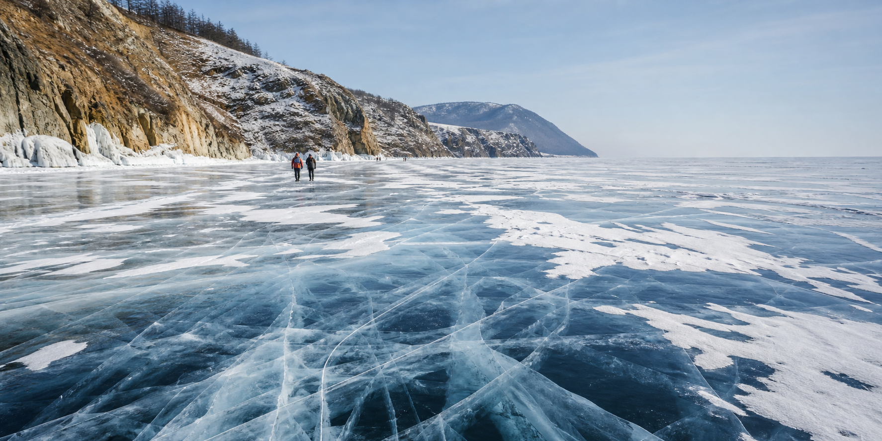Guided travellers crossing varied clear and snow-covered winter ice beside Lake Baikal cliffs